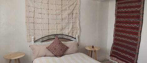 2 dormitorios y tabla de planchar con plancha