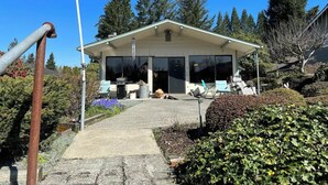 A house with a covered patio, a grill, and a flagpole. - 1 Bedroom Retro Riverside Home with view ! (Sultan)