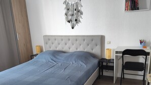 Un dormitorio con una cama, un escritorio y una silla.