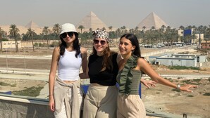 Three people standing on a balcony with a view of pyramids in the background. - Galleria Pyramids View Hotel (Giza)