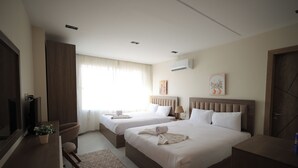 A hotel room with two beds, a TV, a desk, and a window with curtains. - Galleria Pyramids View Hotel (Giza)