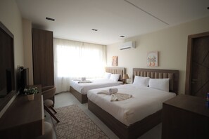 A hotel room with two beds, a TV, a desk, and a window with curtains. - Galleria Pyramids View Hotel (Giza)