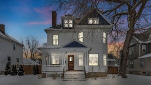 A two-story house with a front porch, a chimney, and a number '146' on the front door. - Spacious 5-bedroom house with parking and everything you need in charming Elyria (Elyria)