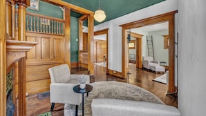 A spacious living room with a high ceiling, wooden staircase, and a chandelier. - Spacious 5-bedroom house with parking and everything you need in charming Elyria (Elyria)