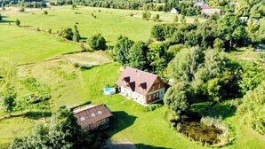 An aerial view of a house with a large yard, surrounded by trees and open fields. - ApaLuza - Ideal for families. Comfort & relaxation in nature. Horses and pool! (Stara Kamienica)