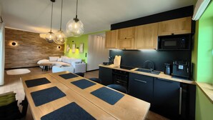 A modern kitchen with wooden cabinets, a black countertop, and a built-in microwave. - ApaLuza - Ideal for families. Comfort & relaxation in nature. Horses and pool! (Stara Kamienica)