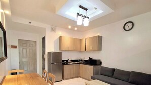 Un espacio habitable compacto con zona de comedor, kitchenette y sofá.