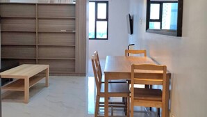 Un comedor moderno con una mesa y sillas de madera, un banco y un espejo grande en la pared.
