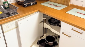 A compact kitchen with white cabinets, a wooden countertop, a built-in oven, and a small sink. - Ruhr Business Apartments Essen 7 beds Parking lot (Essen)