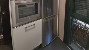 A compact kitchen with a built-in oven and a refrigerator.