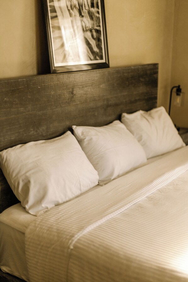 A bed with white bedding and a wooden headboard.