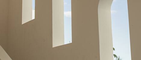 A corridor with three arched windows.