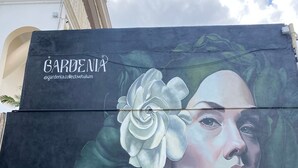 Un mural en un edificio con una flor grande y el texto 'GARDENIA' y '@gardenia.collectivetulum'.