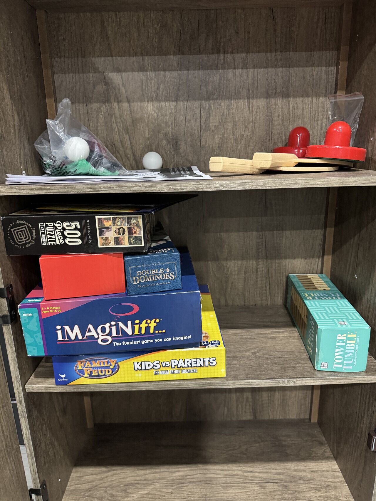 A shelf with various board games and a puzzle box.