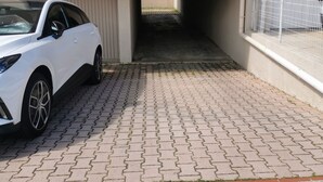 A white car parked in a covered driveway with a balcony above. - Studio 16 mcarré kicnetteet frigo compartiment congelateur micro ondes (Perpignan,)