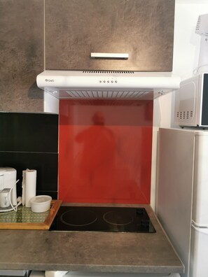 Enjoy cooking in this well-equipped kitchen with a stainless steel range hood, stovetop, and microwave oven.