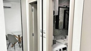 A modern kitchen with a washing machine, a sink, and a mirror. - Lux Apartment Nina&Martina new 2025 (Split)