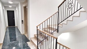 A modern interior with a marble staircase, a hallway leading to a door, and a ceiling light. - Lux Apartment Nina&Martina new 2025 (Split)