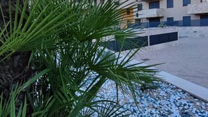 A residential building with multiple balconies, a gravel pathway, and green foliage. - Lux Apartment Nina&Martina new 2025 (Split)