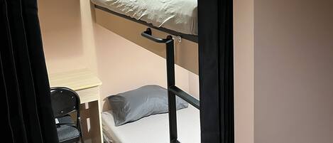 A bunk bed with a desk and chair in a small room.