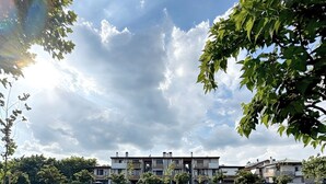 A grassy field with a bench and a row of buildings in the background. - Bed & Bergamo Holiday Home in neighborhood surrounded by greenery, 5km from the airport! (Bergamo)