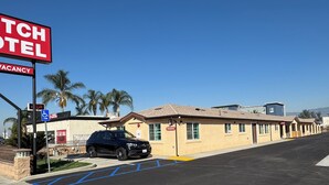 A Dutch Motel with a vacancy sign, handicap accessible parking, and a row of single-story buildings. - Dutch Motel (Loma Linda)