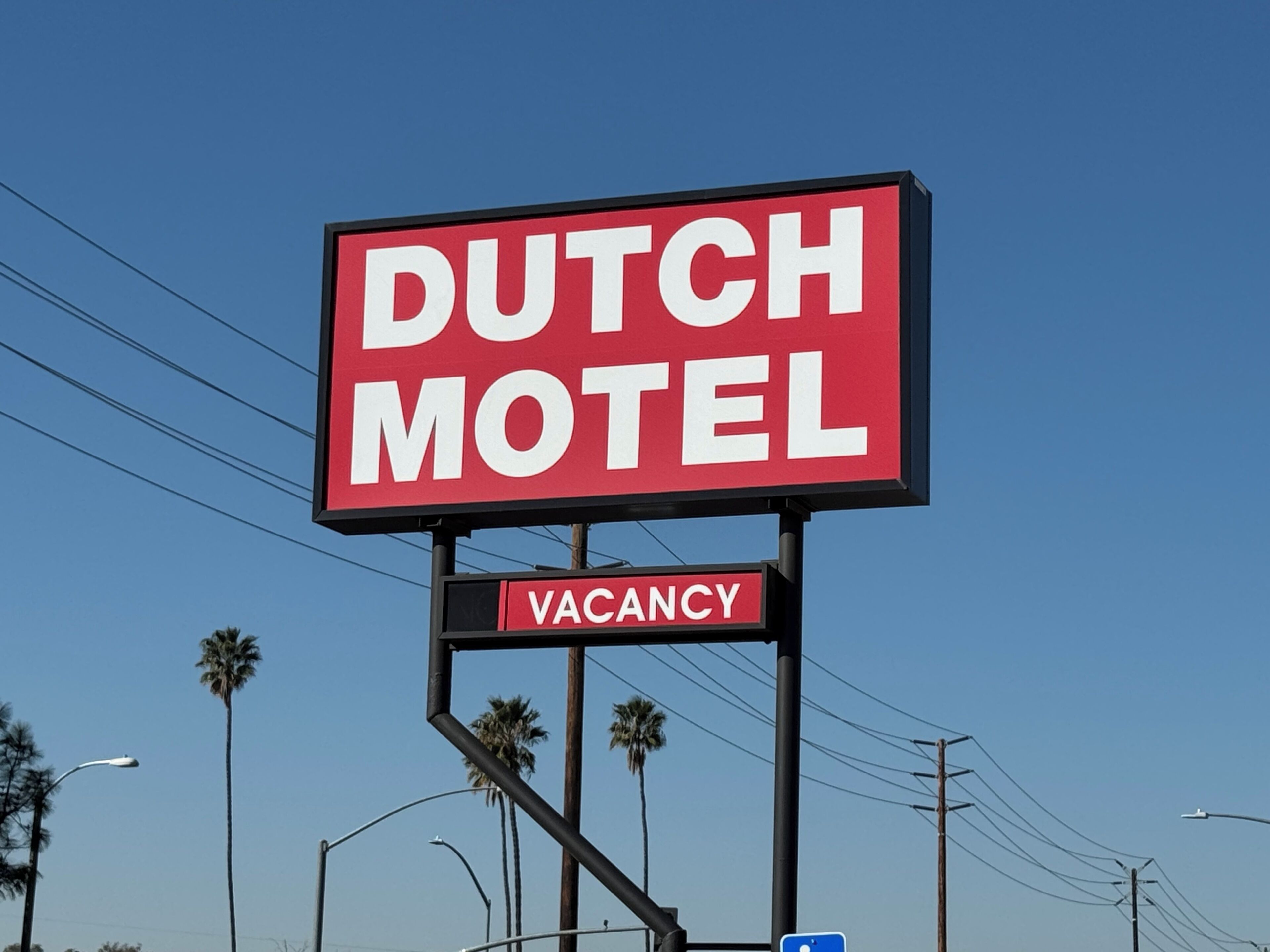 Señal del Motel Holandés con aviso de habitaciones disponibles.