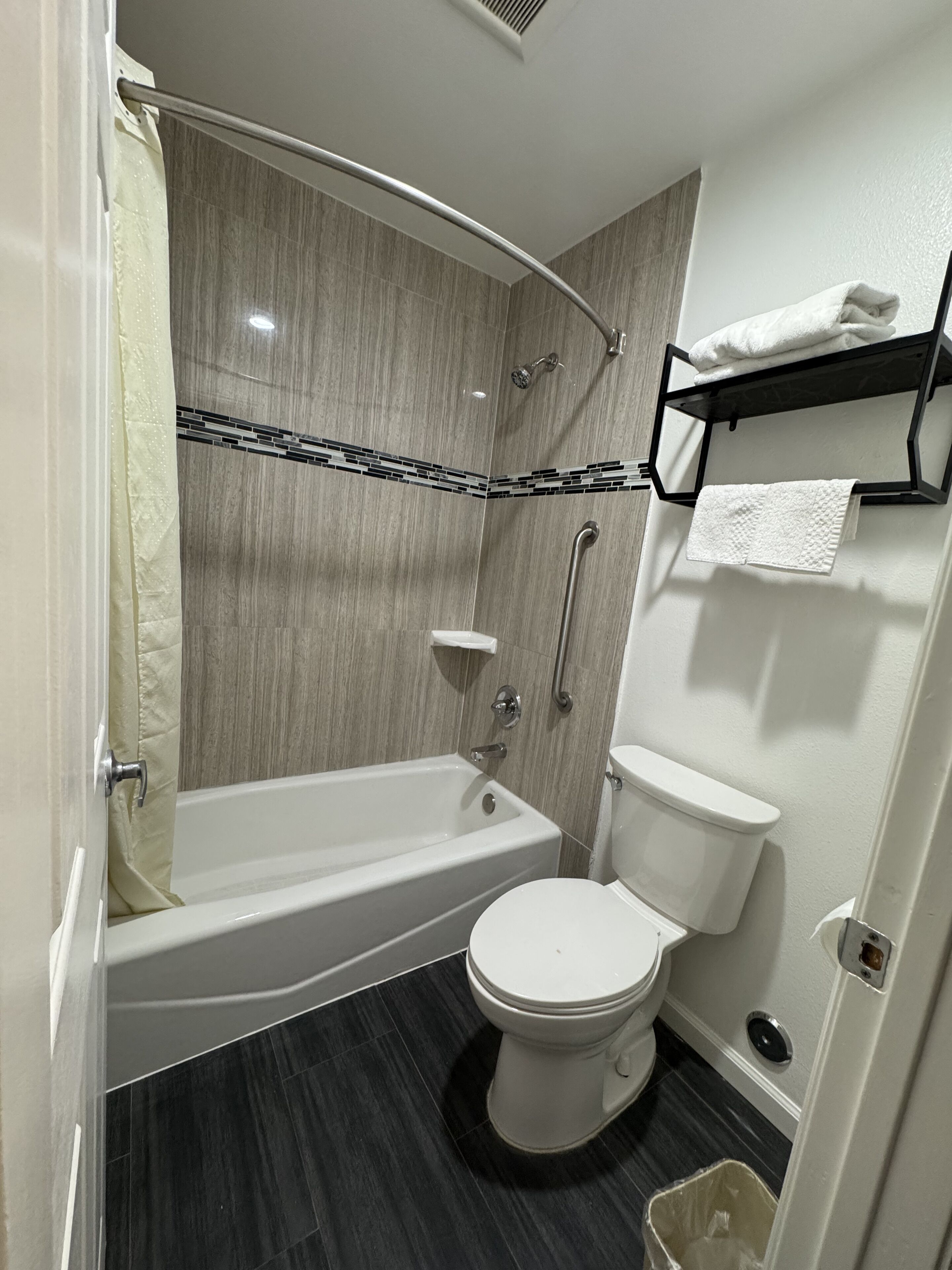 Een moderne badkamer met een bad, toilet en douche.