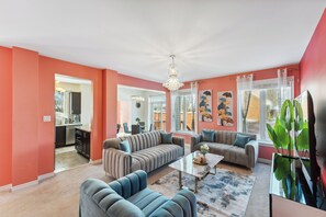 A living room with a sectional sofa, a coffee table, and a large plant. - Luxury 4BR Home, Sleeps 10,  Private & Near Shops in Ottawa (Ottawa)