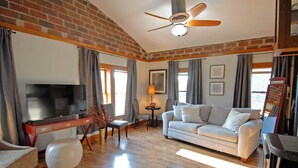 A living room with a TV, sofa, and a desk. - "Historic Loft Retreat in Downtown Bloomington" (Bloomington)