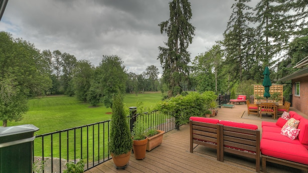 A deck with a red sofa and a table, surrounded by potted plants. - Romantic cottage with tranquil outdoor space in Willamette Valley Wine Country (Independence)