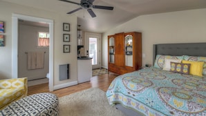 A bedroom with a bed, a wardrobe, a ceiling fan, and a bathroom visible through an open door. - Romantic cottage with tranquil outdoor space in Willamette Valley Wine Country (Independence)
