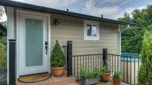 A house with a front door, a small window, and a porch with steps. There are potted plants on the porch. - Romantic cottage with tranquil outdoor space in Willamette Valley Wine Country (Independence)