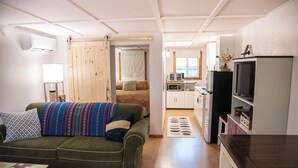 Een knus woongedeelte met een bank, een televisie en een kitchenette.