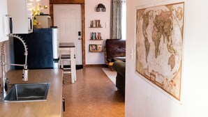 Een moderne keuken met een inbouwspoelbak en een eethoek met een witte tafel en stoelen.