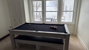 A pool table in a room with a window overlooking a snowy outdoor area. - Lakefront Retreat w/ Kayaks, Firepit & Home Office.  Beautiful Sunsets! (Constantia)