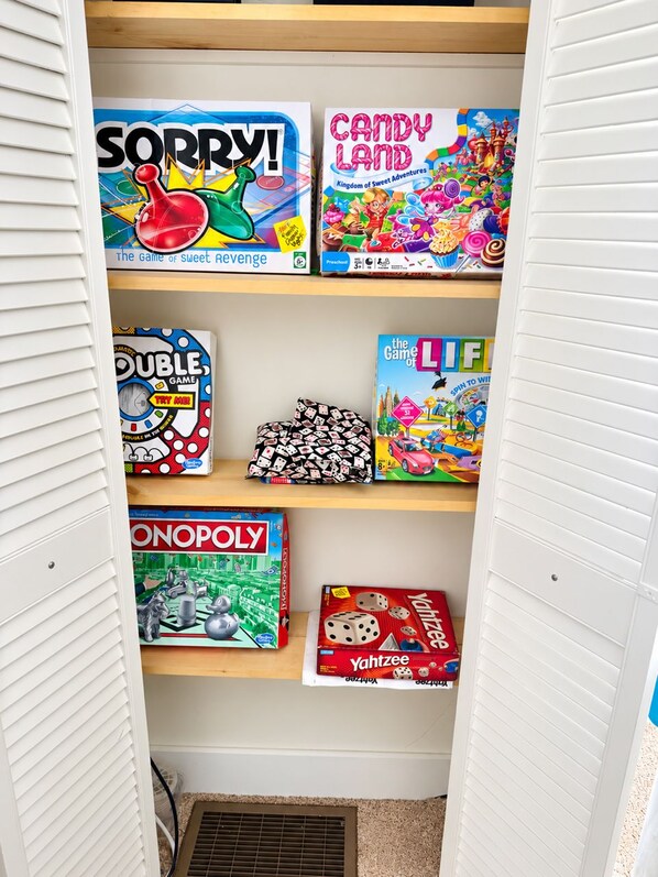 A shelf with various board games including Monopoly and Candy Land.