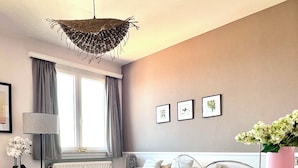 A modern living room with a white sofa, a glass coffee table, a fluffy rug, and a clear chair. - Appartement Proche de l'Otan (Brussels)
