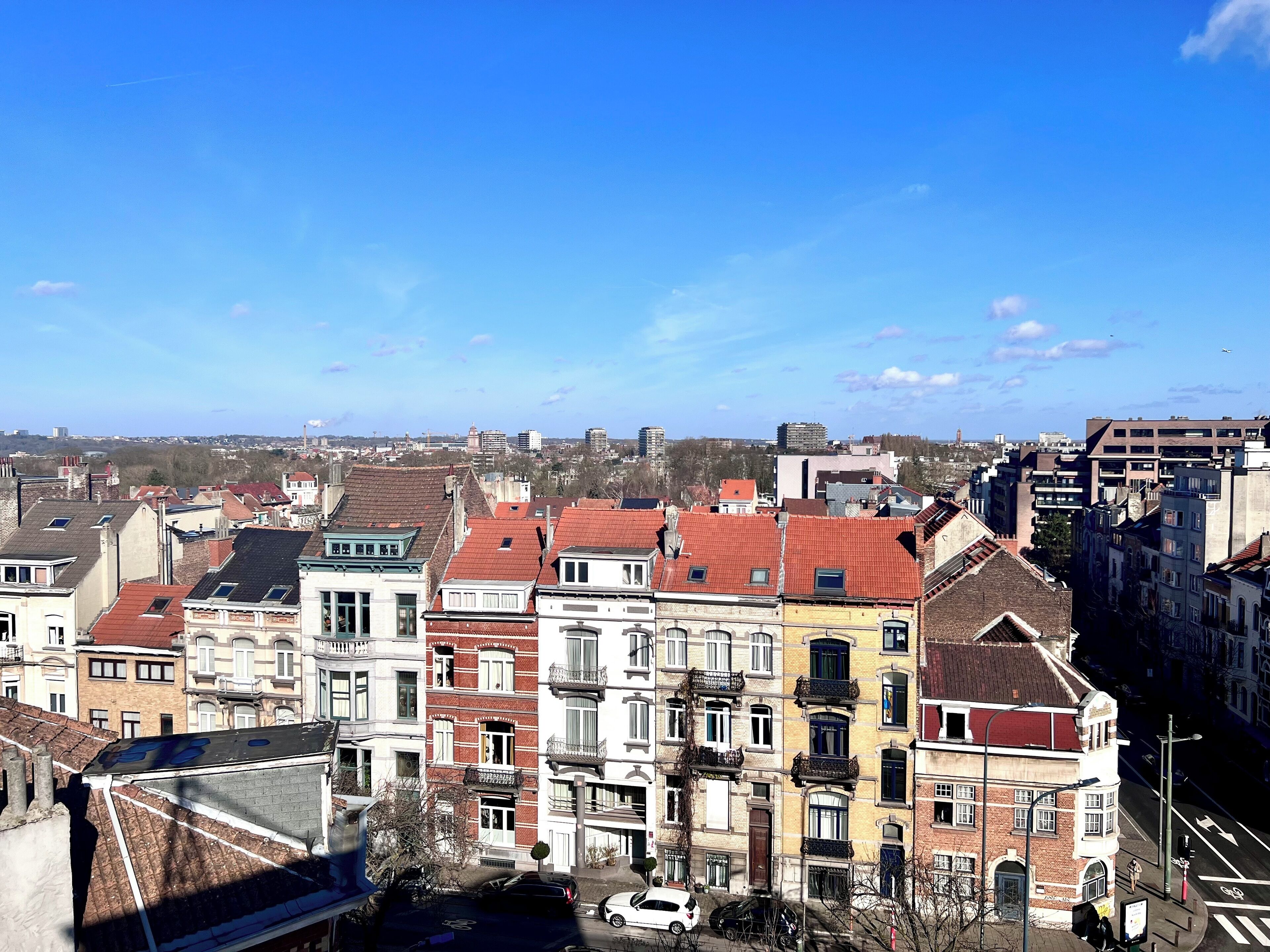 Een stadsgezicht met diverse gebouwen, waaronder meerder woon- en bedrijfspanden met verschillende architectuurstijlen.