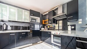 Una cocina moderna con una isla central, electrodomésticos integrados y vistas al área de estar.