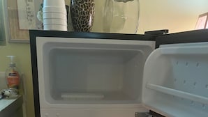 Ein offener Kühlschrank mit durchsichtigen Schubladen und einem Gefrierfach.