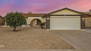 A residential house with a garage, a driveway, and a landscaped front yard. - Charming 3-bedroom house with Pool, WiFi and AC in amazing Mesa (Mesa)
