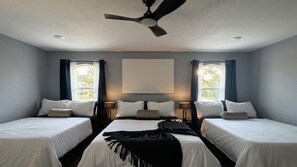 A hotel room with two single beds, a ceiling fan, and a large window with curtains. - Pickleball HotTub MiniGolf with Downtown FW Views! (Fort Worth)