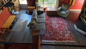 A cozy living room with a sofa, armchairs, a coffee table, and a patterned rug. - Dragon’s Nest on River. Quiet Get-away (Tweed)
