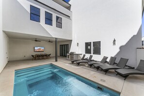 A modern outdoor pool area with lounge chairs, a barbecue grill, and a dining set. - Zion's Sunset is BRAND NEW!!! Beautiful courtyard, fun game room, roof top deck (Hurricane)