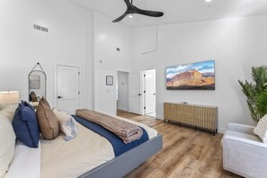 A modern bedroom with a bed, bedside table, and a large window.