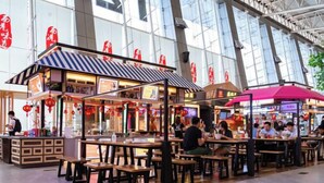 An indoor food court with multiple dining tables and booths, surrounded by large windows. - Western Airport Aviation Hotel (Xi'an Airport) (Xianyang)