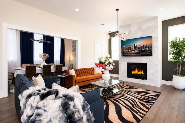 Een moderne woonkamer met een bank, salontafel en een open haard.