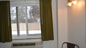 A room with a window, curtains, an air conditioner, and a chair. - #30- TWO QUEEN BEDS in enjoyable Columbia Falls with WiFi, AC, 20m mi to GNP!! (Columbia Falls)