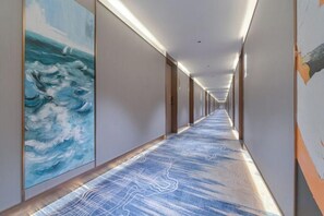 A long corridor with a patterned carpet, artwork on the walls, and doors on the right. - Antai International Hotel (Zhongkai Bus Terminal Store) (Huizhou)